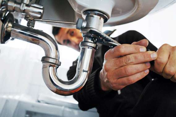Professional plumber from Aqua Squad working on plumbing system